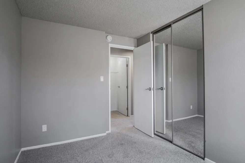 Unfurnished bedroom with carpet and mirrored closet