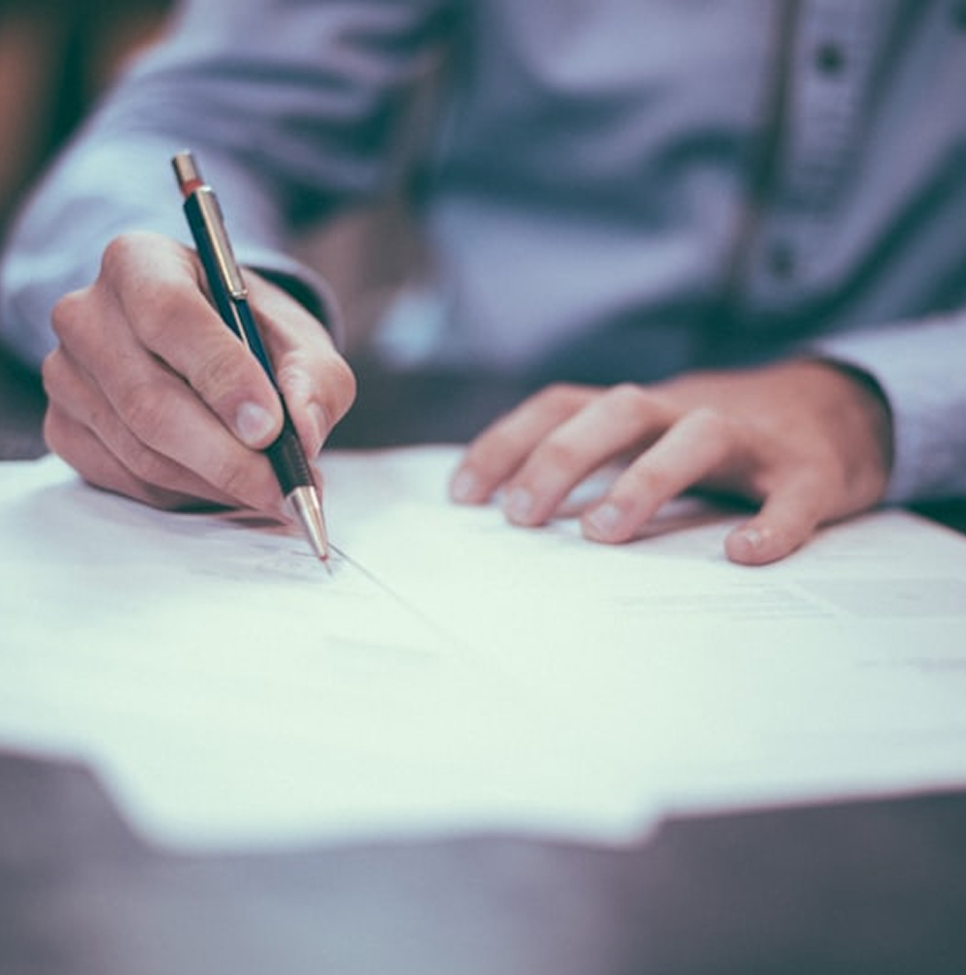 Close-up of a hand signing a business document