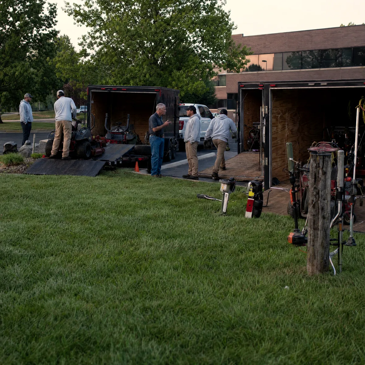 Landscaping owner briefing the crew at the trailers at first light