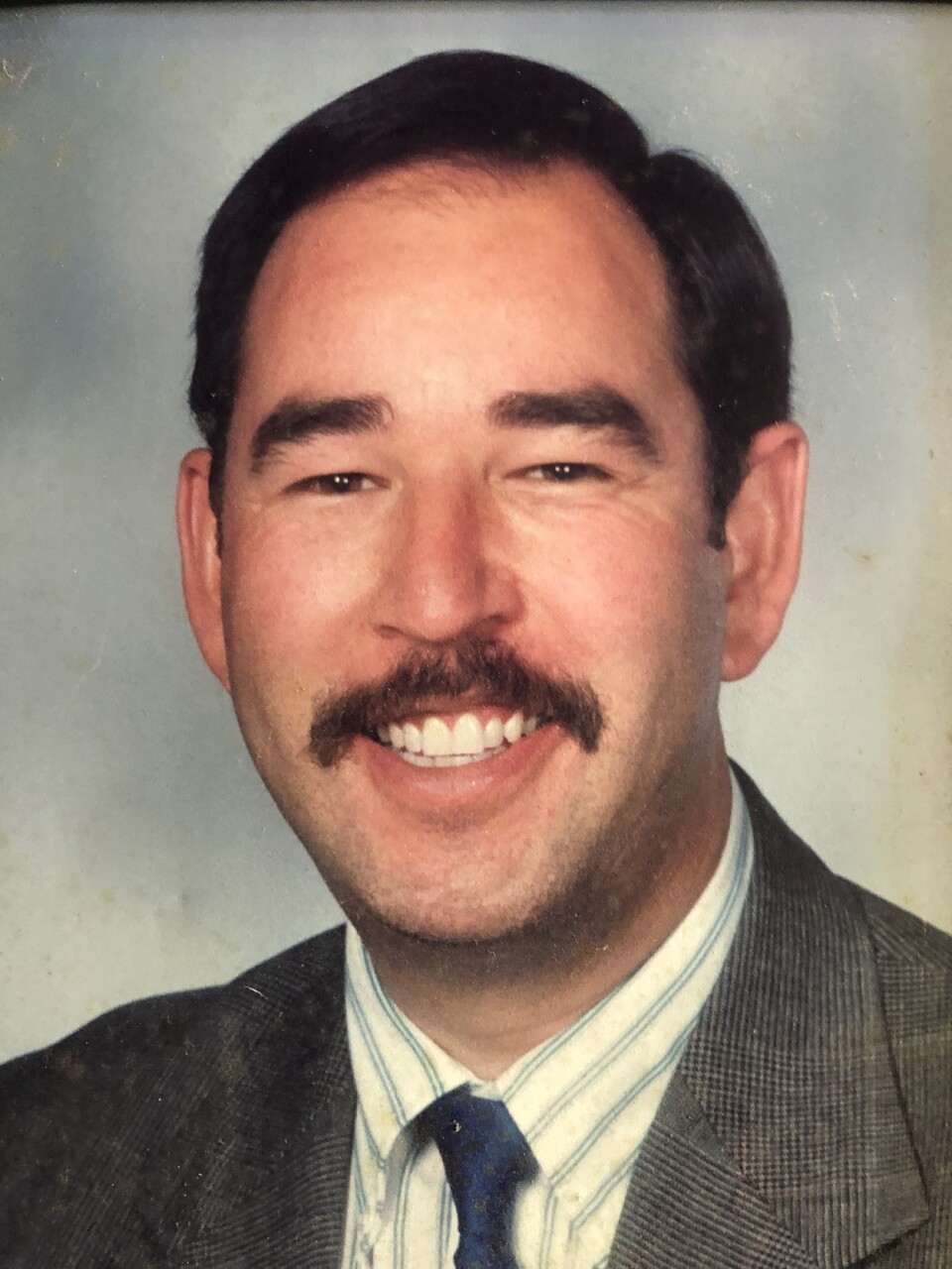 Marcel de Lannoy in a school portrait, smiling, in a checked jacket and striped shirt