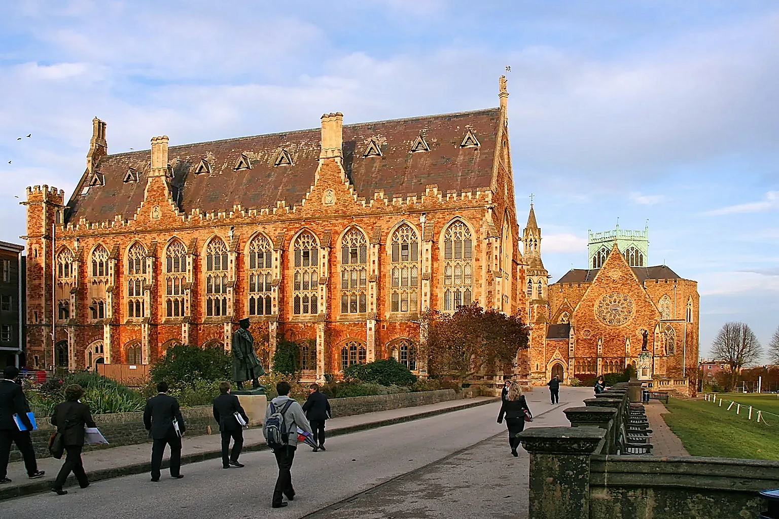 Big School at Clifton College in evening light, with pupils walking in the distance.