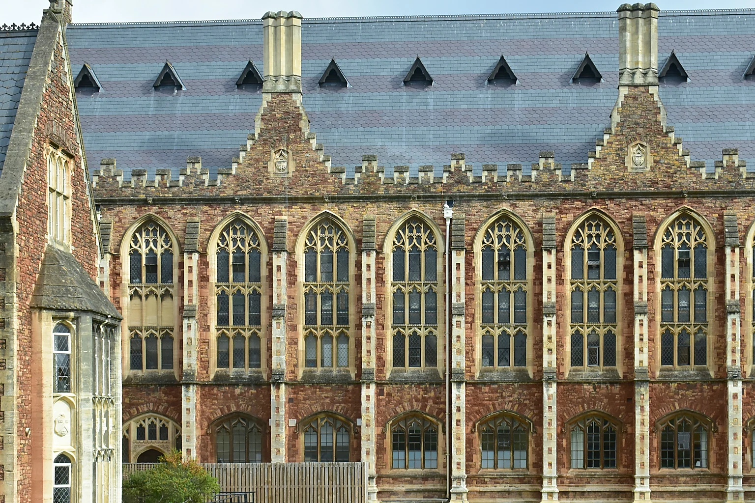 The Gothic facade of Big School at Clifton College, with tall arched windows under a slate roof.