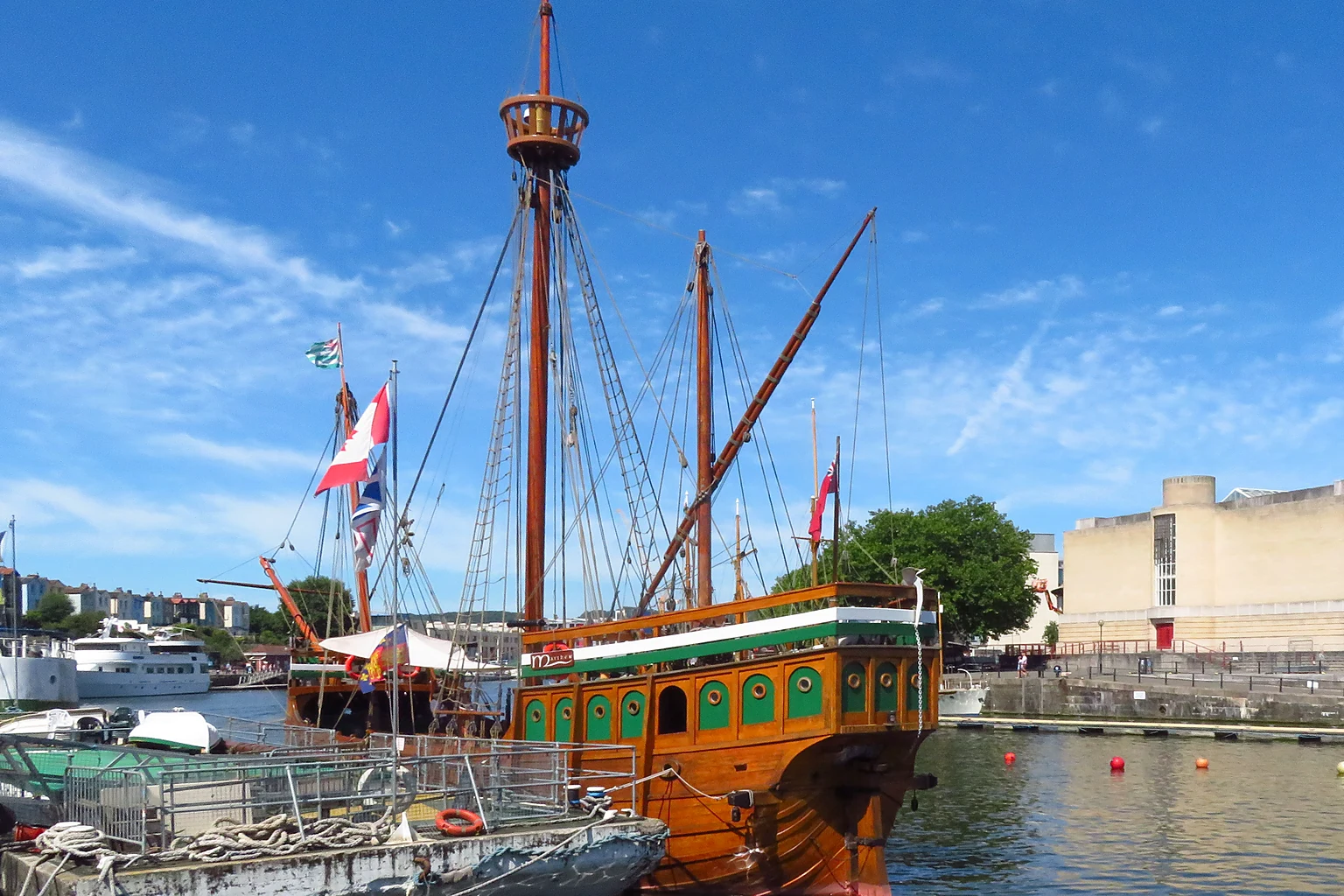 The Matthew, a wooden replica of John Cabot's ship, moored in Bristol's Floating Harbour under a blue sky.