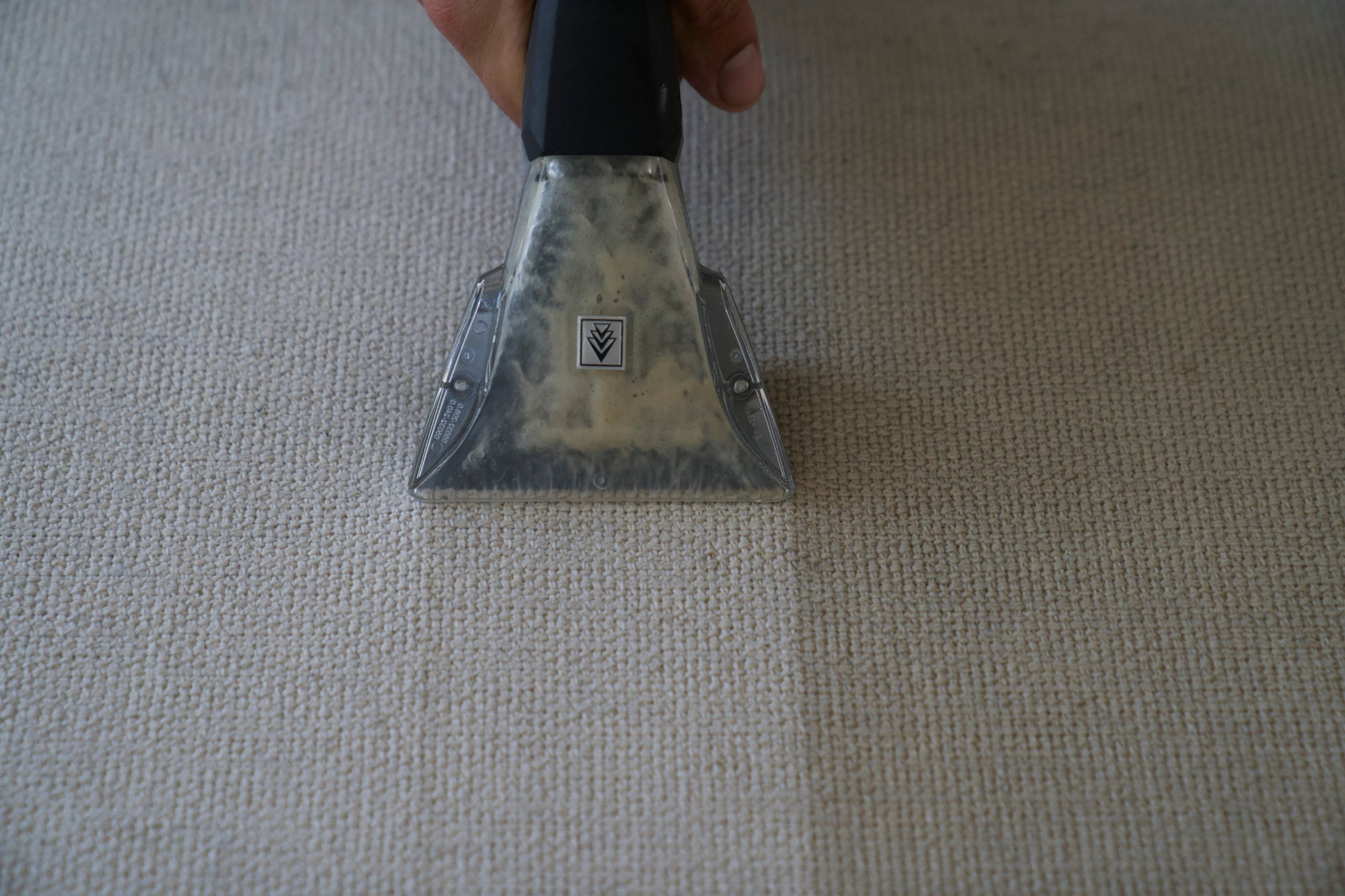 Close-up van de sproei-extractiekop van FRISCH tijdens het dieptereinigen van lichte meubelstof