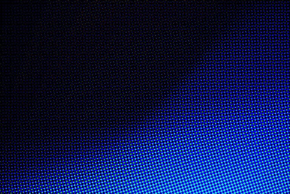 Close-up of blue and black halftone pattern with circular dots in gradient formation.