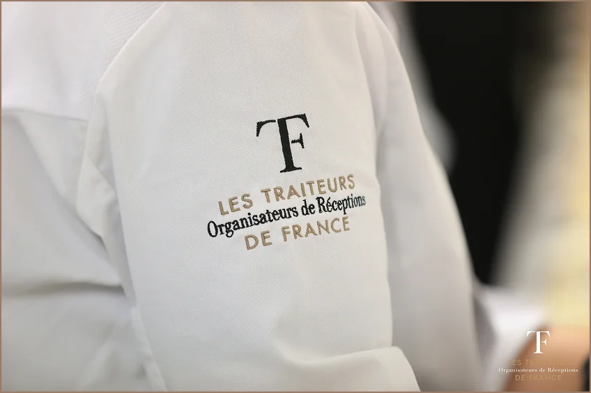 Chef Falcou dressant un atelier culinaire en extérieur sous les parasols