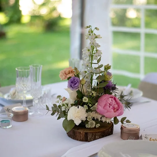 Composition florale de mariage sur socle de bois, réalisée par Relais des Jardins