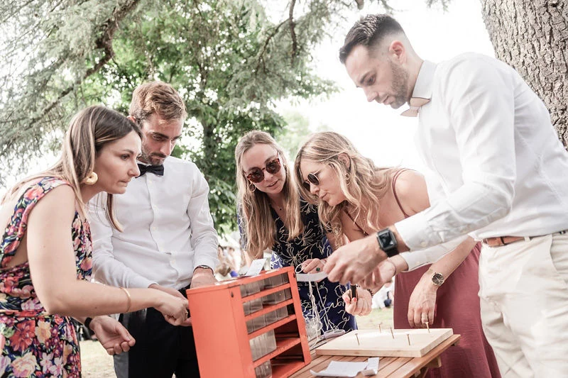 Invités en tenue de mariage jouant à un escape game Mister Wed en extérieur