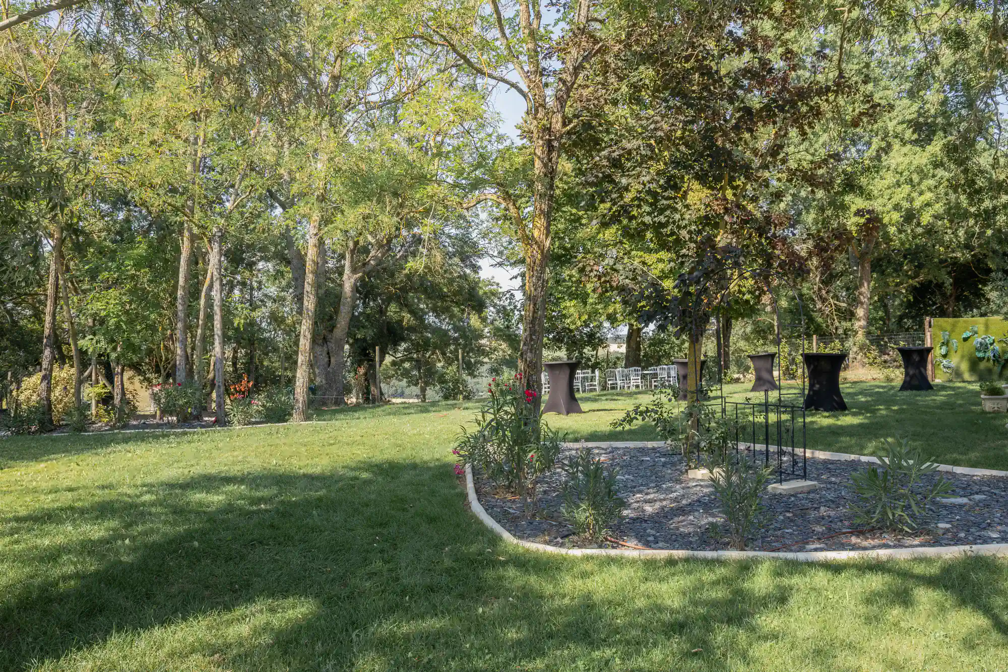 Le jardin arboré du Clos de Montgay dressé en mange-debout pour un vin d'honneur