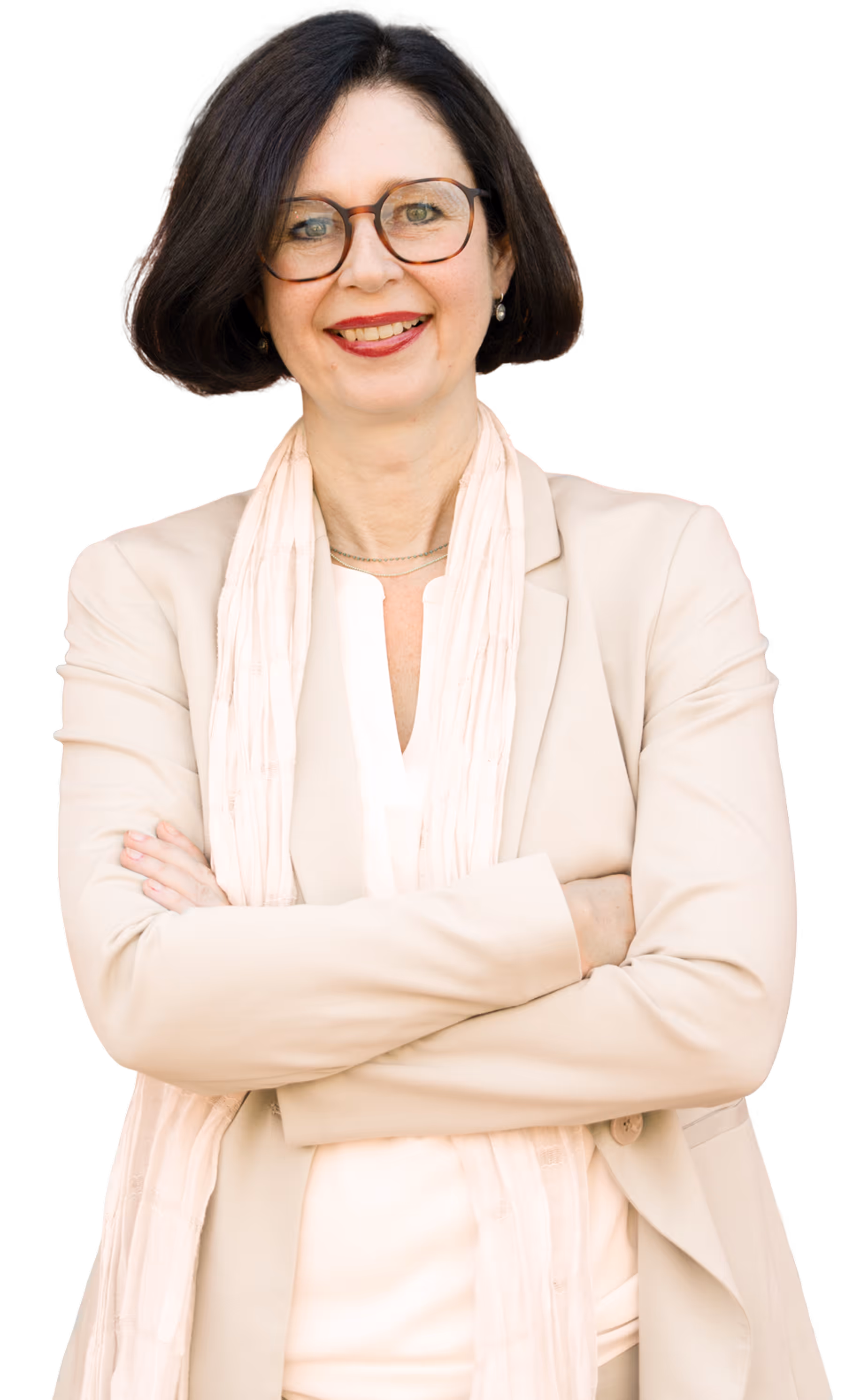 Lächelnde Frau mit dunklen Haaren, Brille und beiger Kleidung, die die Arme verschränkt hält.