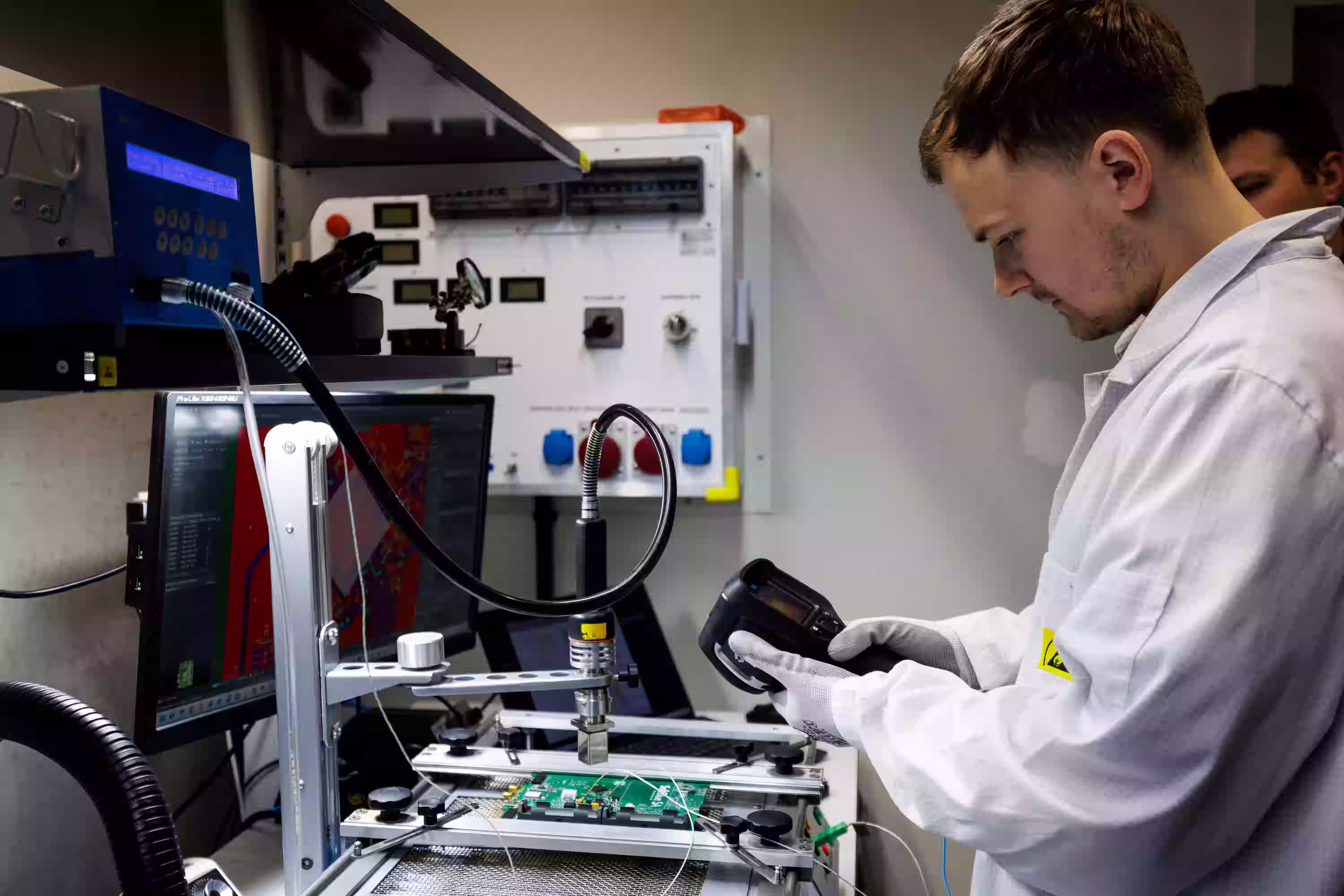 Engineer with thermal camera at a PCB rework station