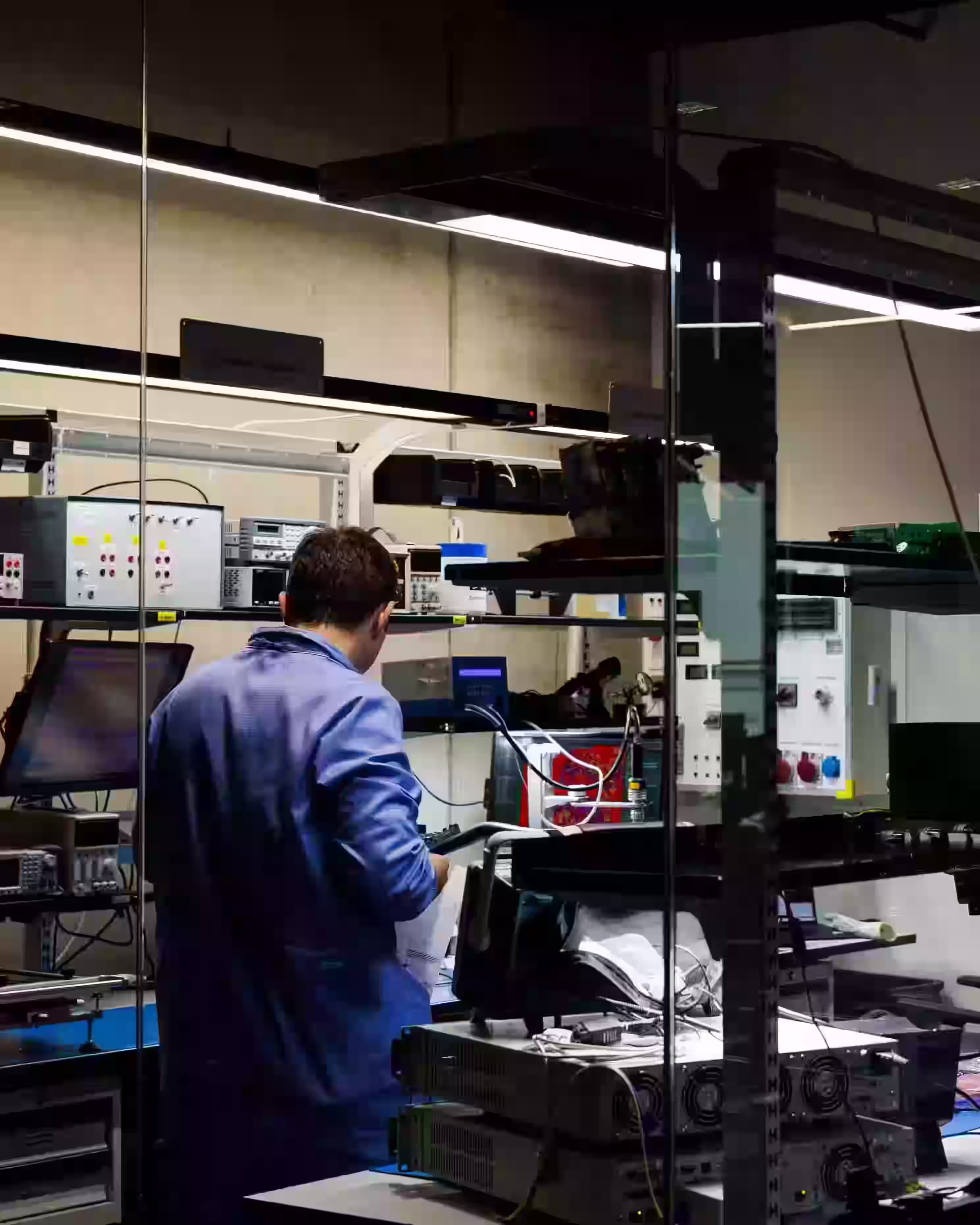 Engineer working with electronic testing equipment in a modern laboratory.