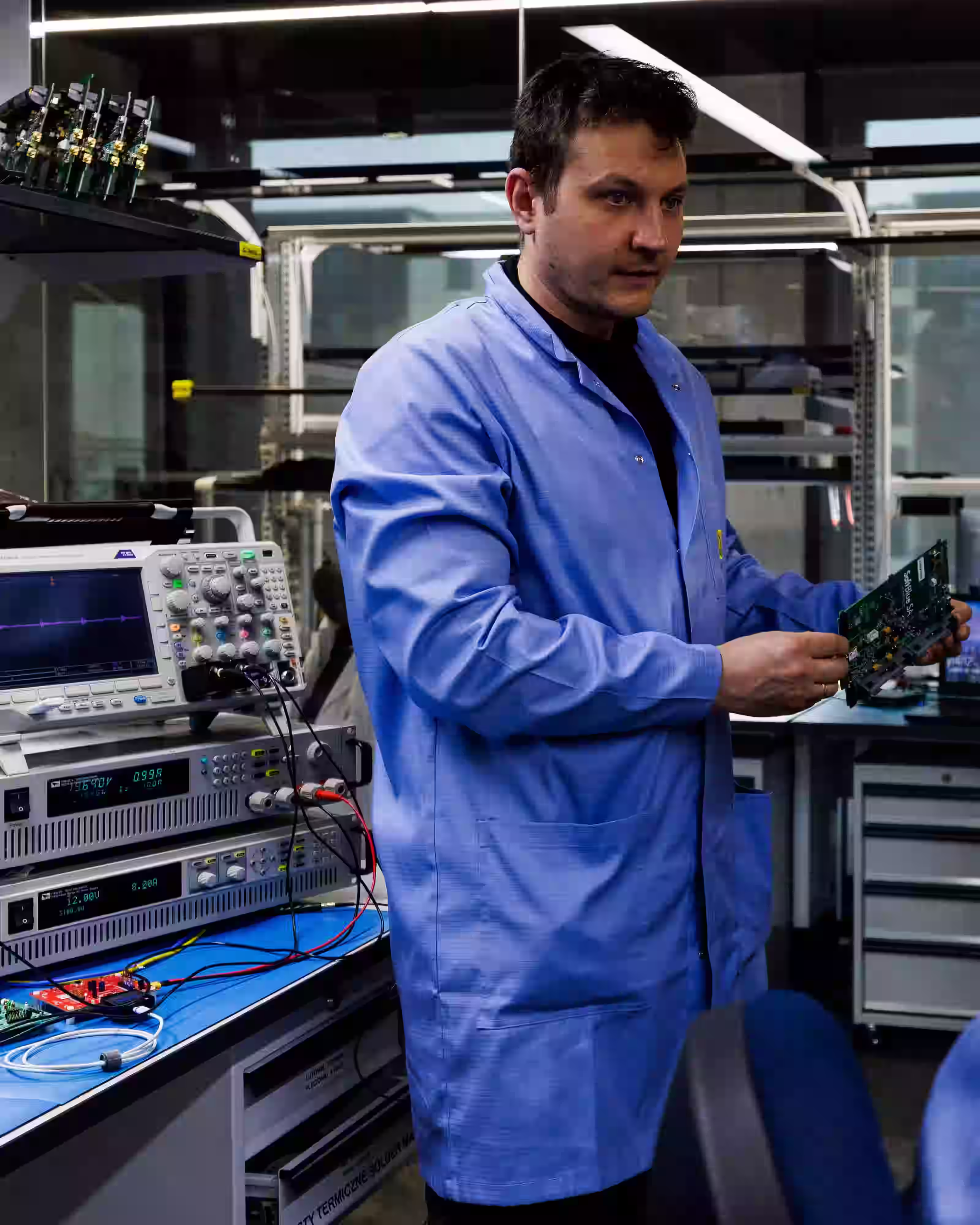 Engineers working with electronic testing equipment in a technology laboratory.