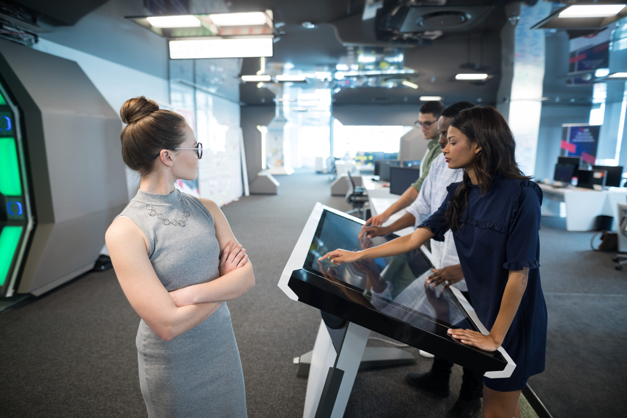 Employees using interactive touchscreen technology in a smart office