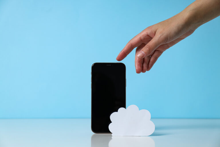 Smartphone and paper cloud symbol representing a cloud-based phone system