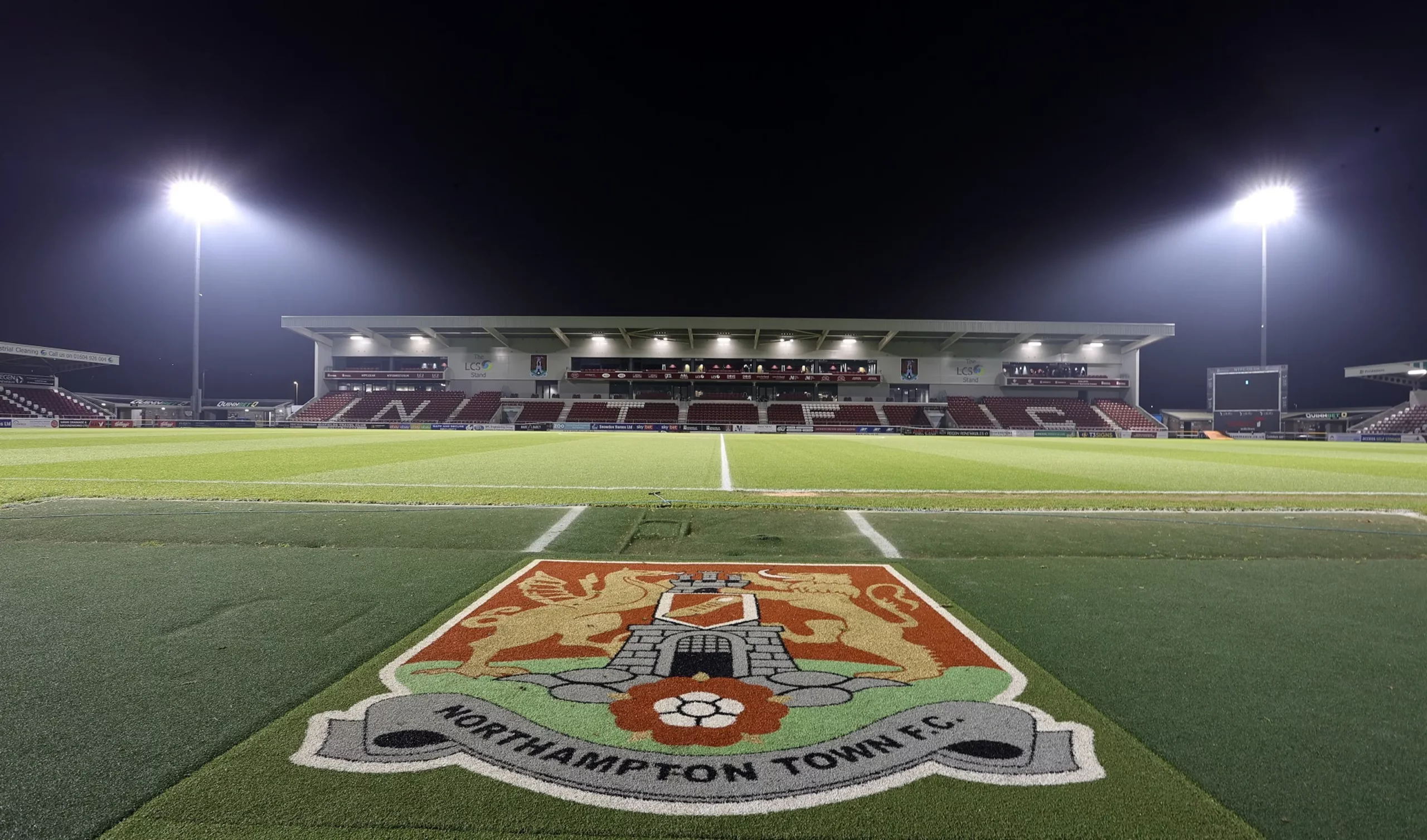 Northampton Town FC's new stand and pitch under floodlights at Sixfields Stadium