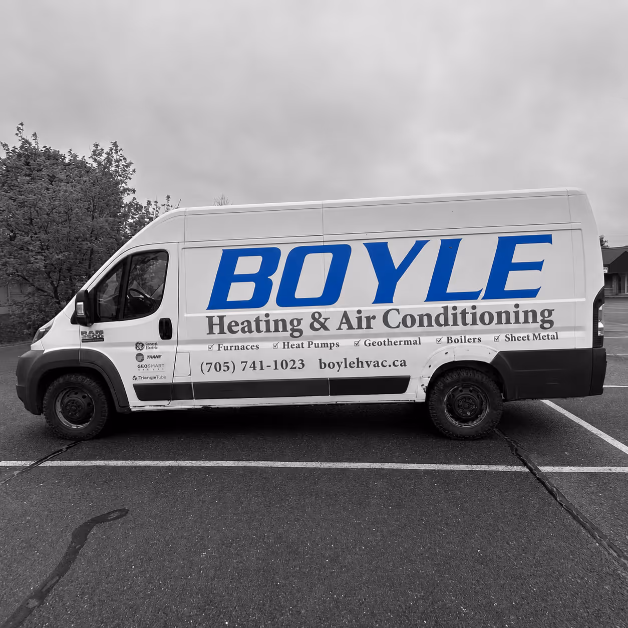 White Boyle Heating & Air Conditioning van with contact info and services listed parked in lot.