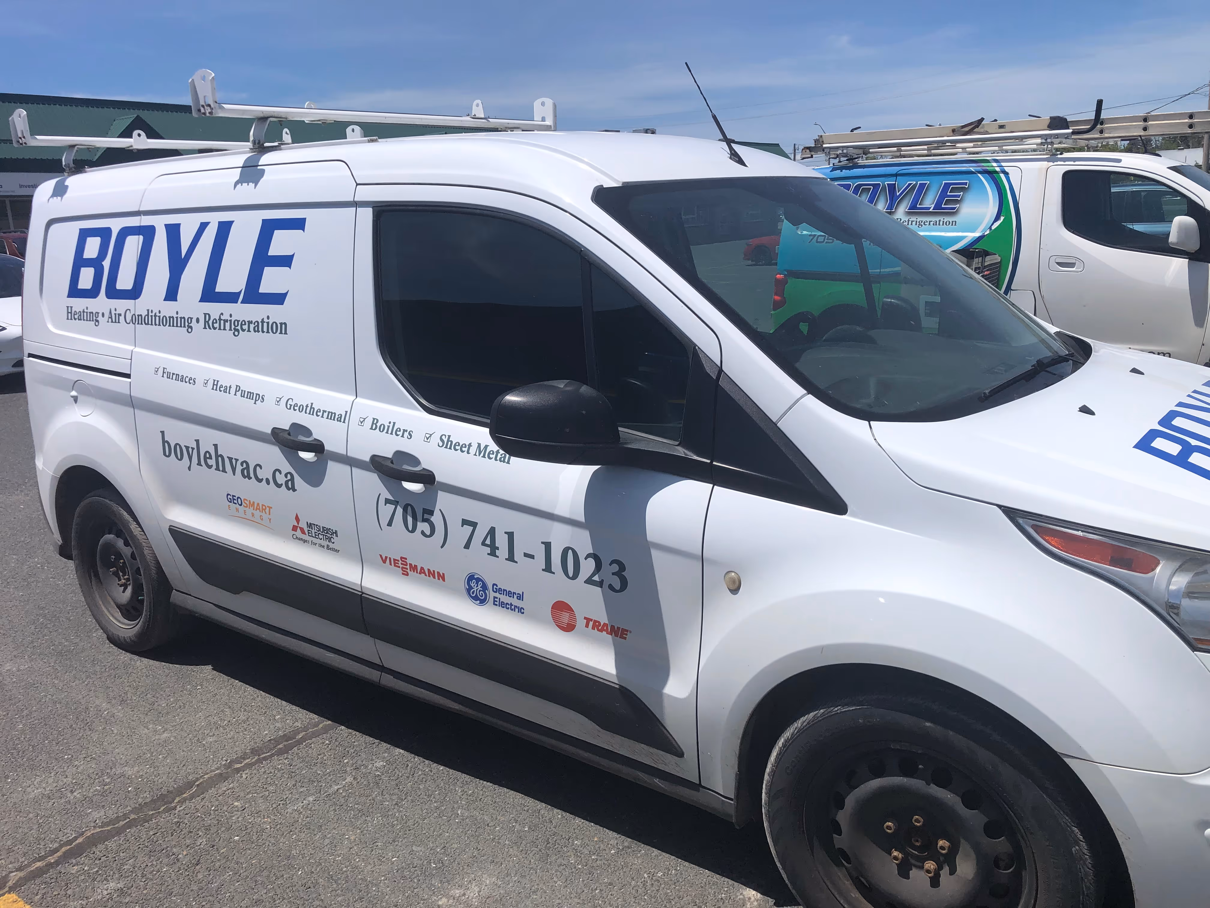 White Boyle Heating Air Conditioning Refrigeration service van with contact info and roof ladder.