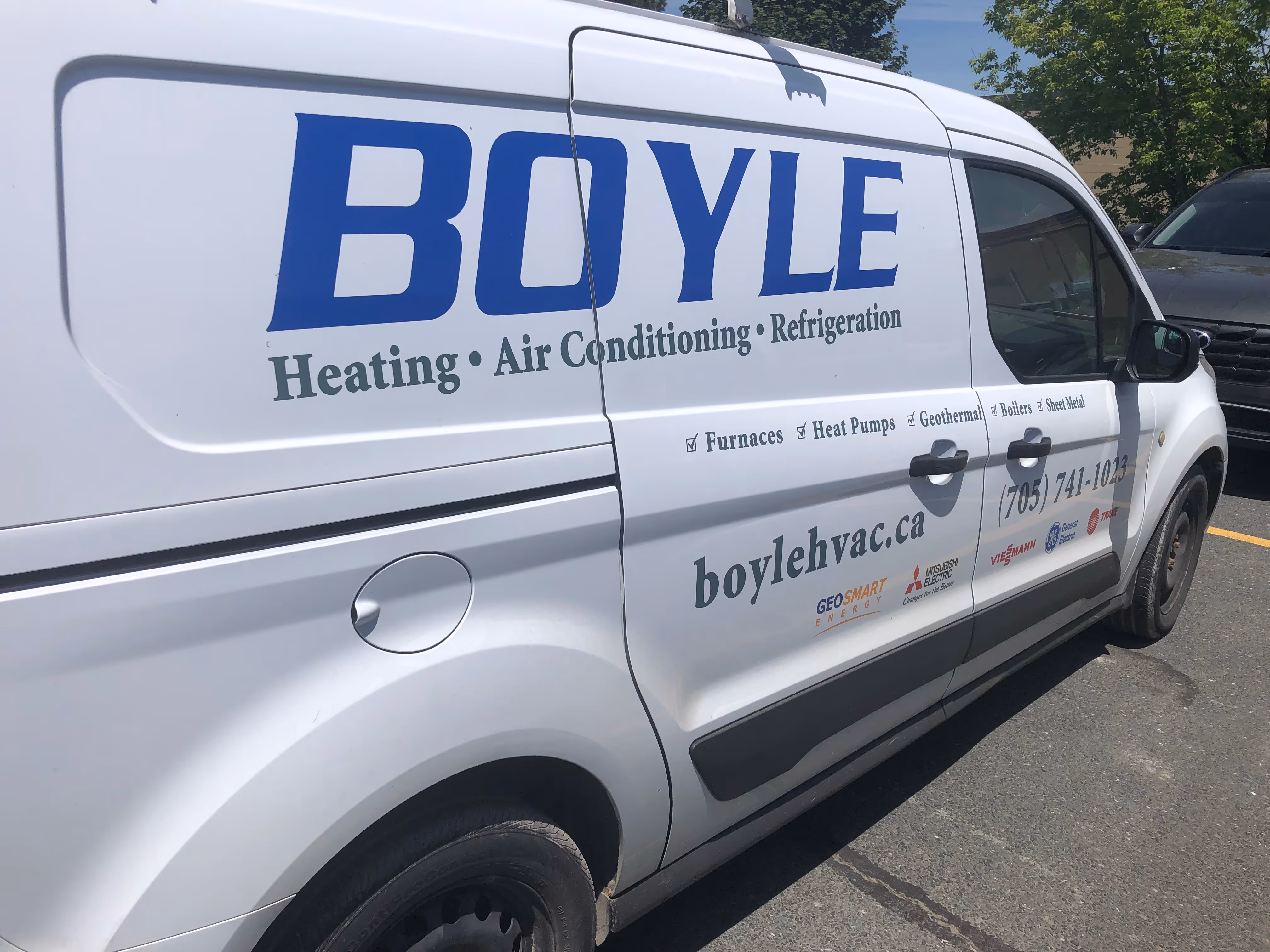White Boyle heating, air conditioning, and refrigeration service van with contact info and logos.