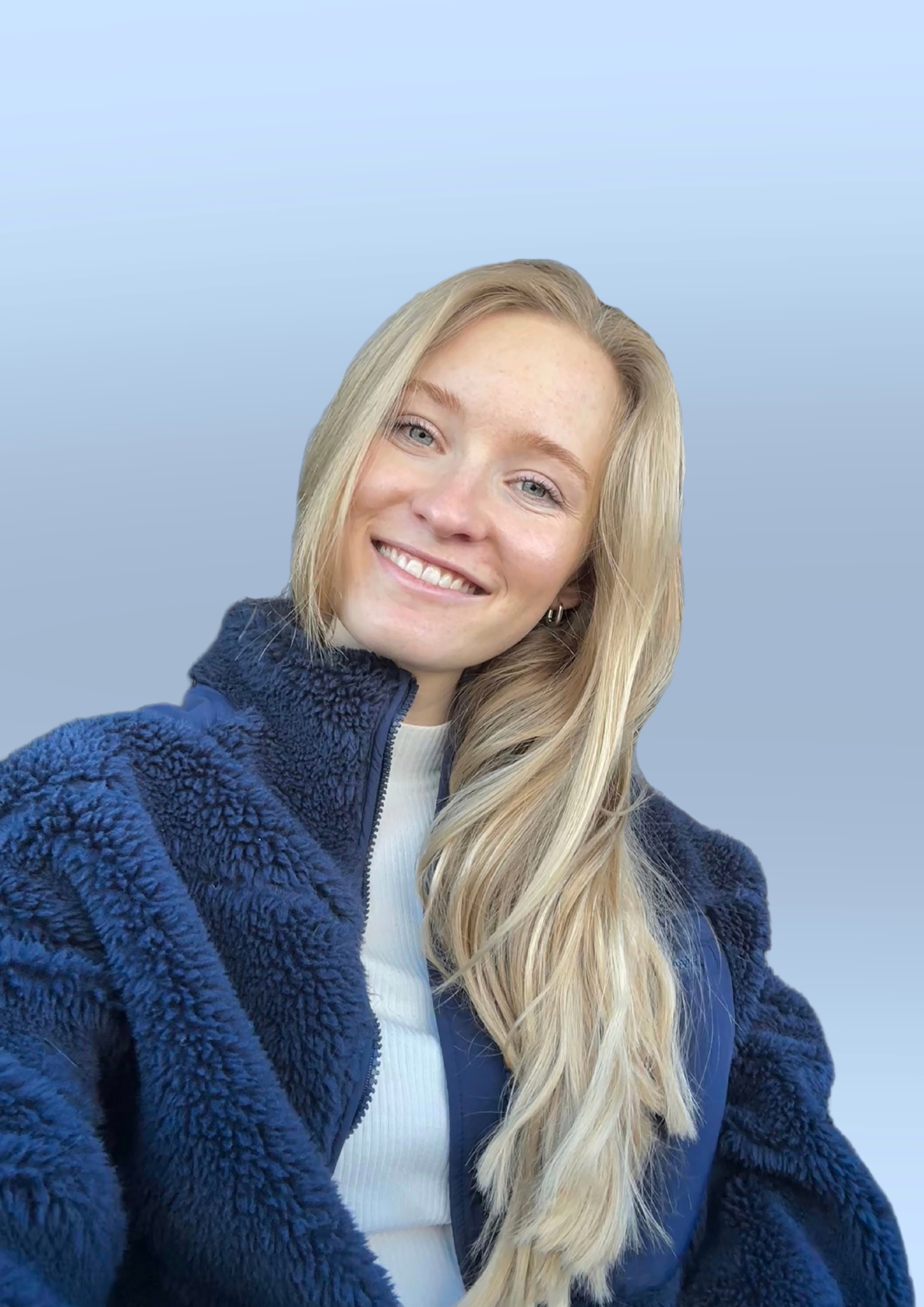 Smiling Joelle Wetzel with long blonde hair wearing a blue fleece jacket and white top against a gradient blue background.