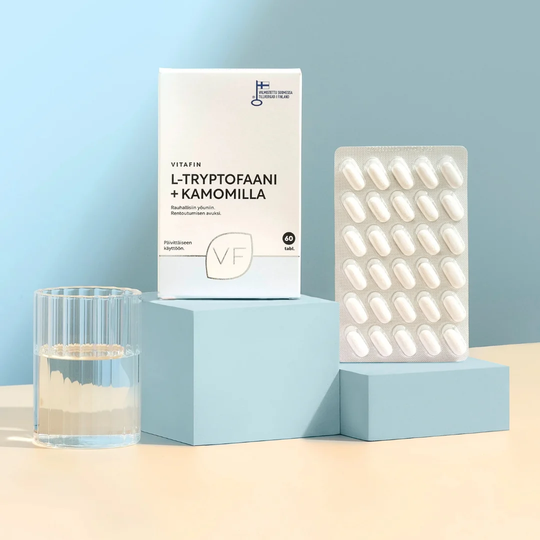 Vitafin L-Tryptofaani + Kamomilla ja tabletit sinisellä korokkeella, vieressä lasi vettä.