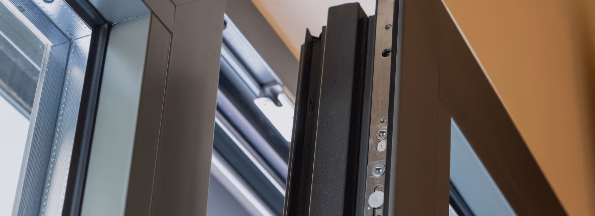 Détail d'une fenêtre moderne en aluminium ouverte montrant le mécanisme de verrouillage.