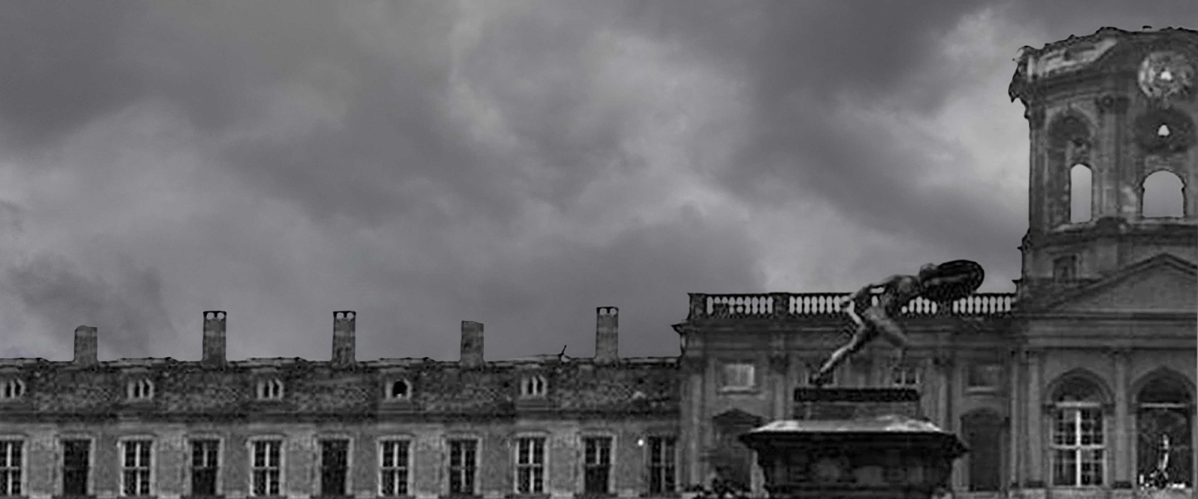 Historic building with statue atop stone pedestal under a cloudy, dark sky in black and white.