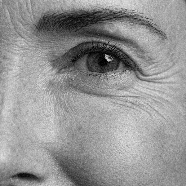 Primer plano en blanco y negro de un ojo femenino con arrugas profundas alrededor