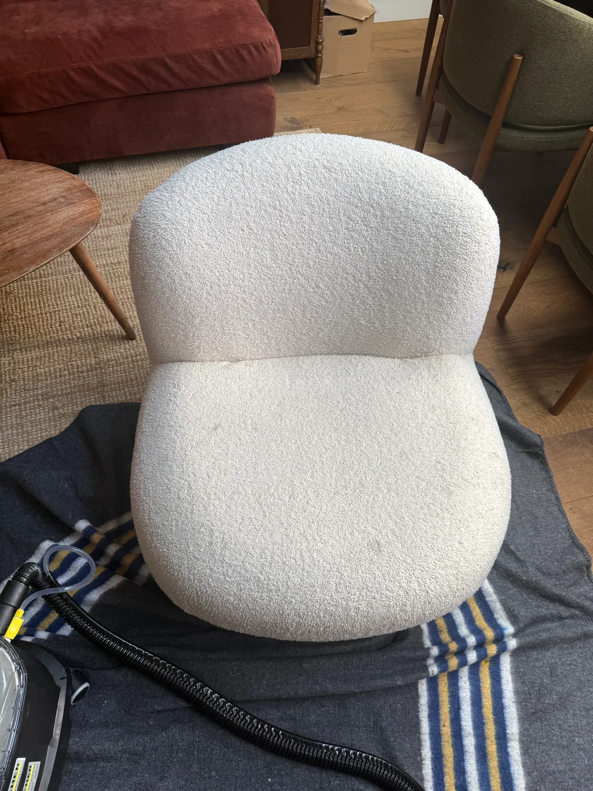 Witte bouclé fauteuil met vlekken op de zitting vóór de reiniging in Eindhoven