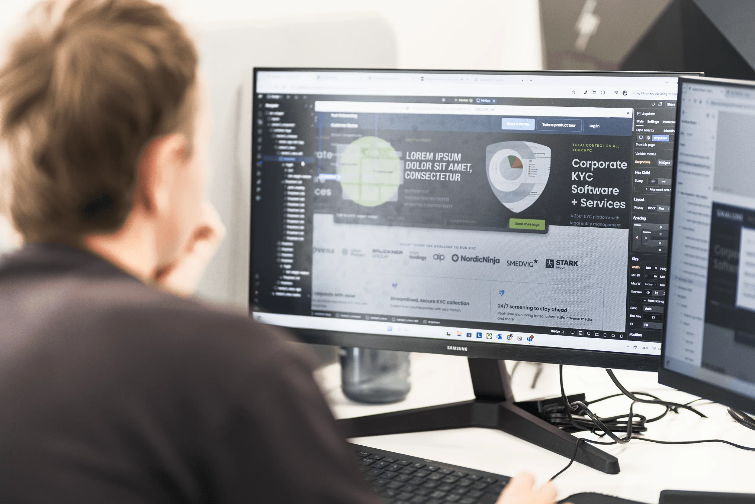Person working on computer with dual monitors displaying corporate KYC software interface.