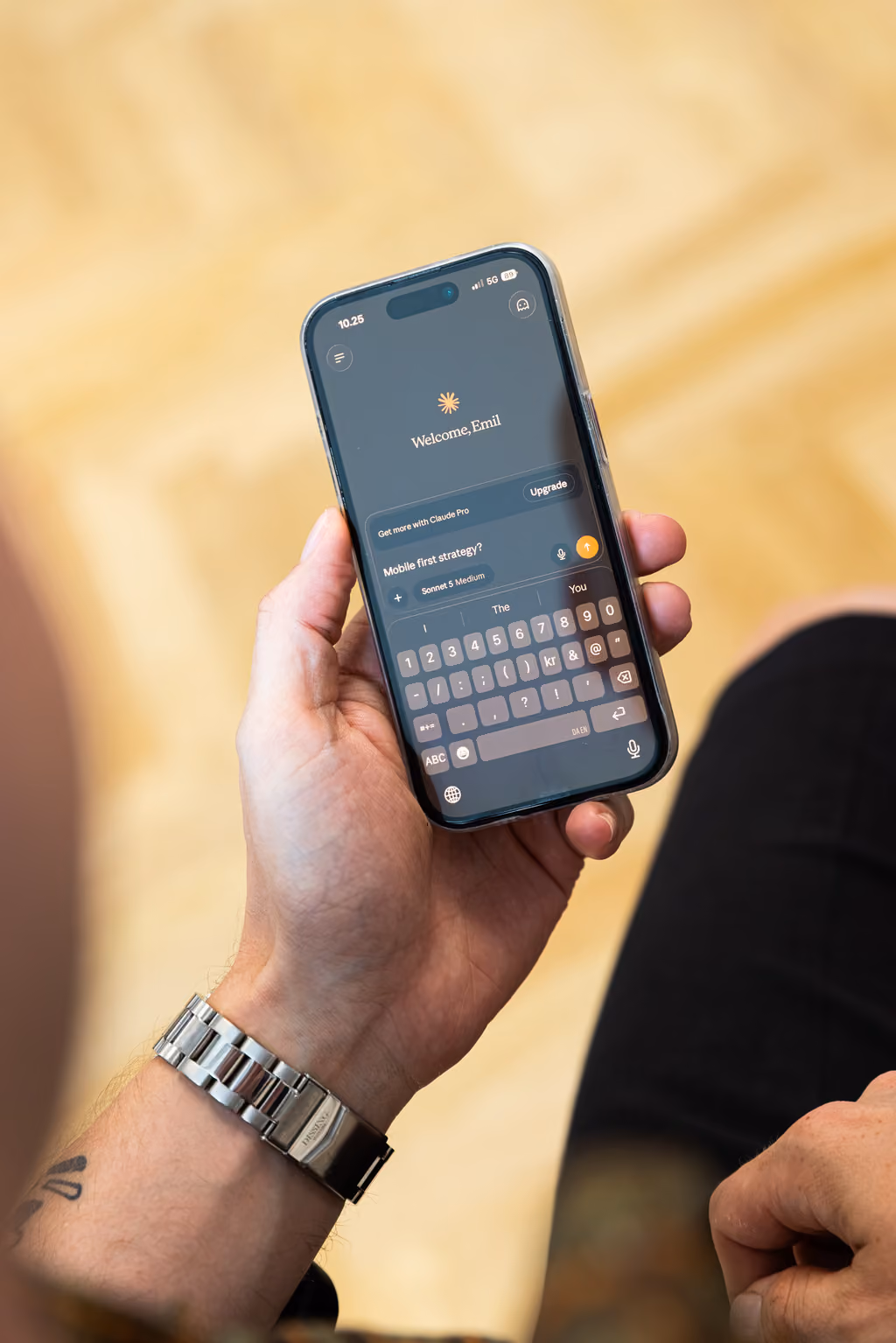 Hånd holder en smartphone med en chat-app, der viser beskeden 'Mobile first strategy?'