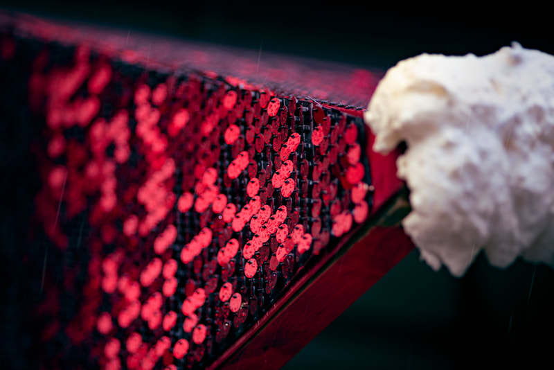 A close-up of a red Shimmerwall sequin backdrop.