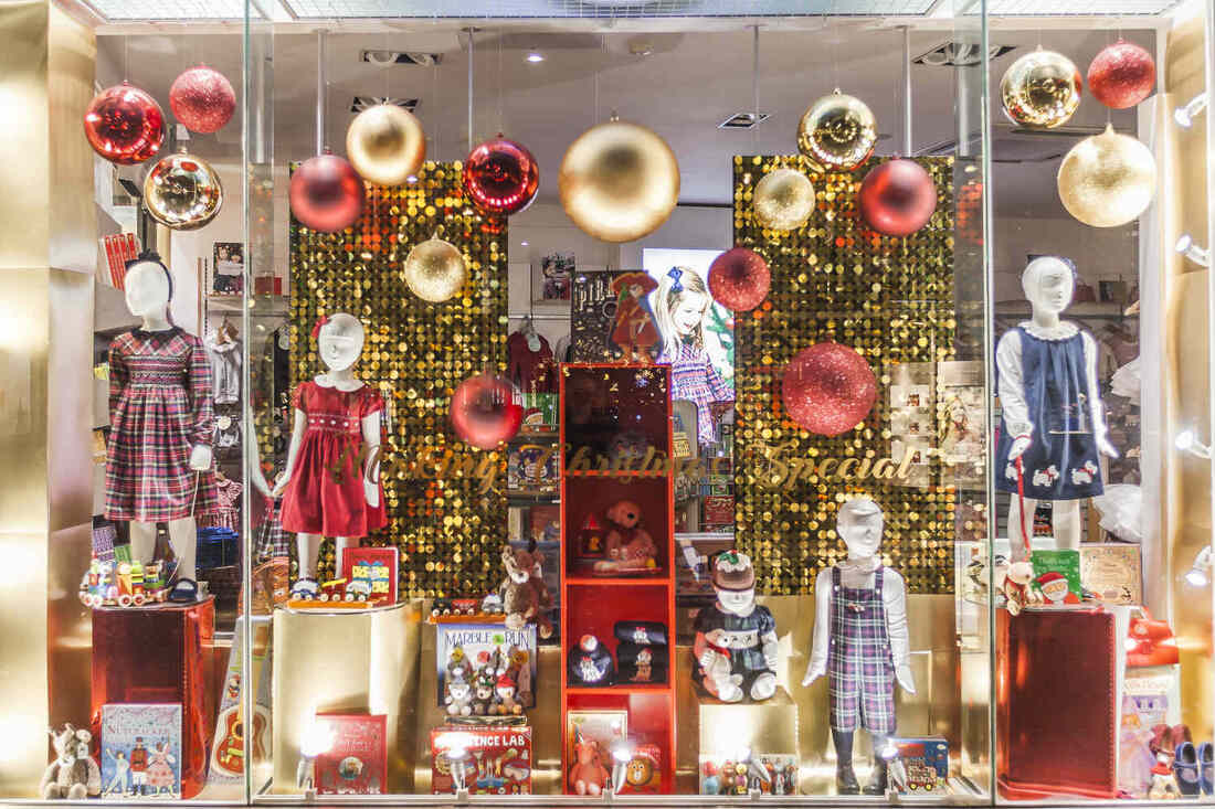 Gold sequin wall, gold and red ornaments, children's mannequins and toys in store window