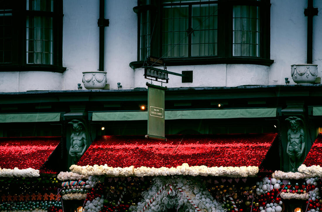 Overhang of green and white building, covered in red sequins with fake snow trim