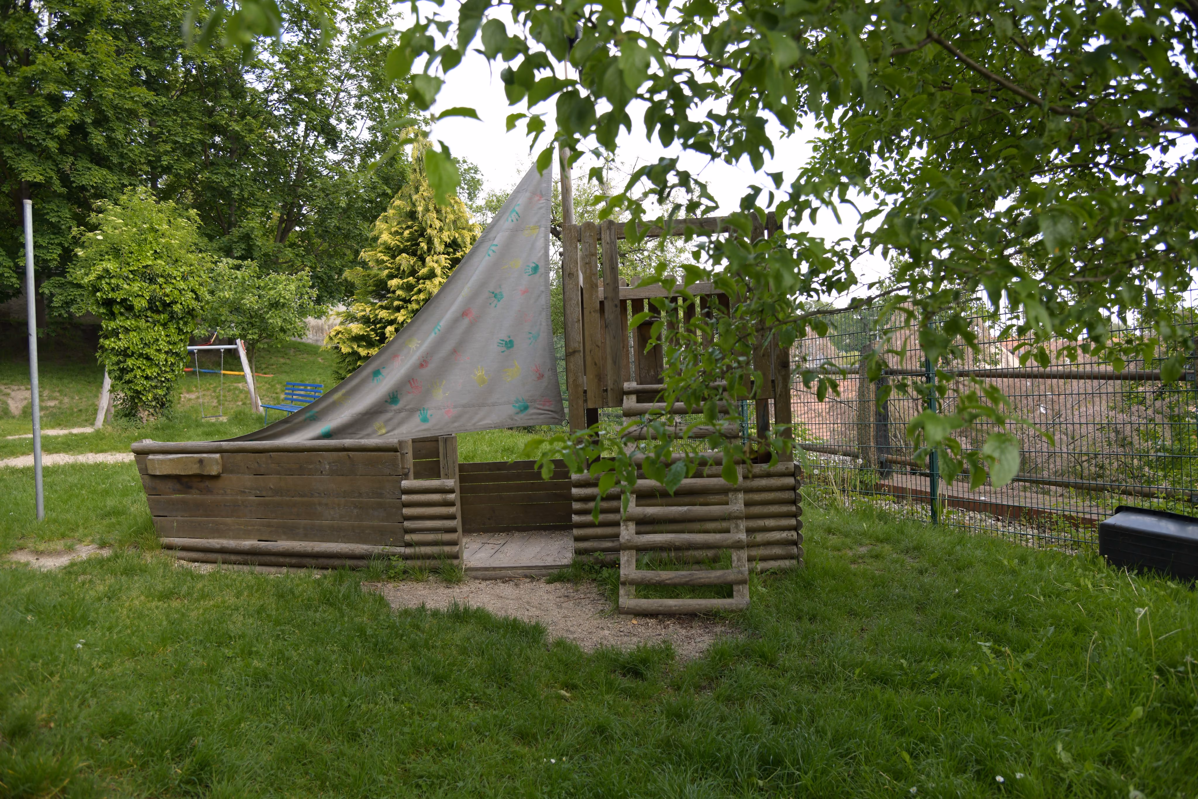 Nahaufnahme des Piratenschiff-Spielgeräts mit bemaltem Segel aus Kinderhandabdrücken.