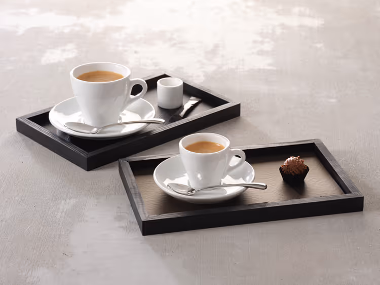 Serviertabletts mit Espressotassen und kleinen Köstlichkeiten für eine stilvolle Kaffeepräsentation.