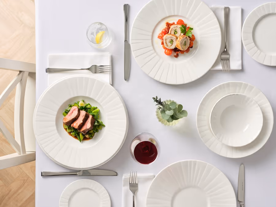 Festlich gedeckter Tisch mit hochwertigem Geschirr, Besteck und Gläsern für ein modernes Gastronomieerlebnis.