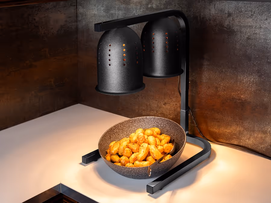 Wärmelampe für das Buffet hält servierte Kartoffeln in einer Schale auf Serviertemperatur.