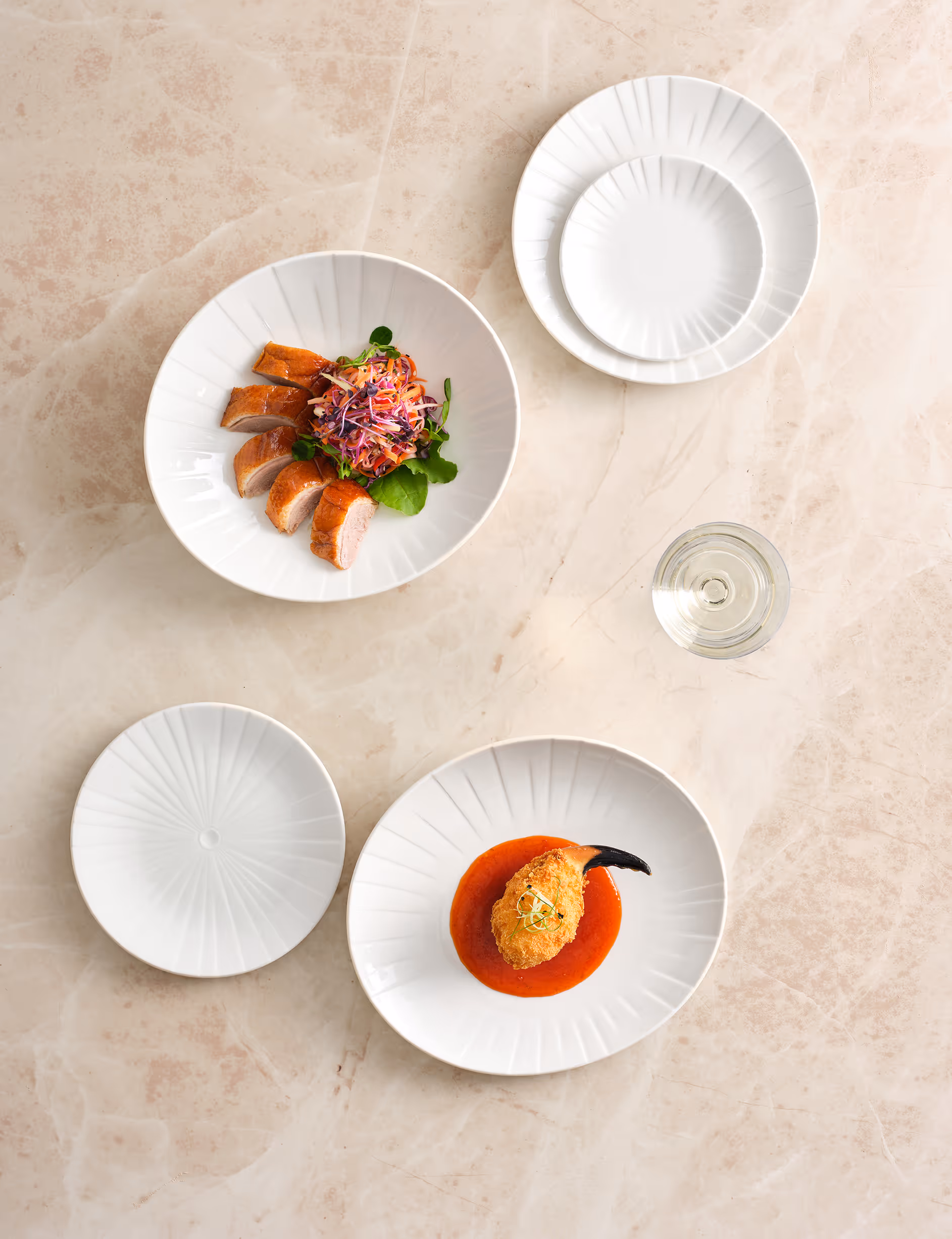 Elegantes weisses Geschirr mit feinen Speisen für eine stilvolle Präsentation in Gastronomie und Hotellerie.