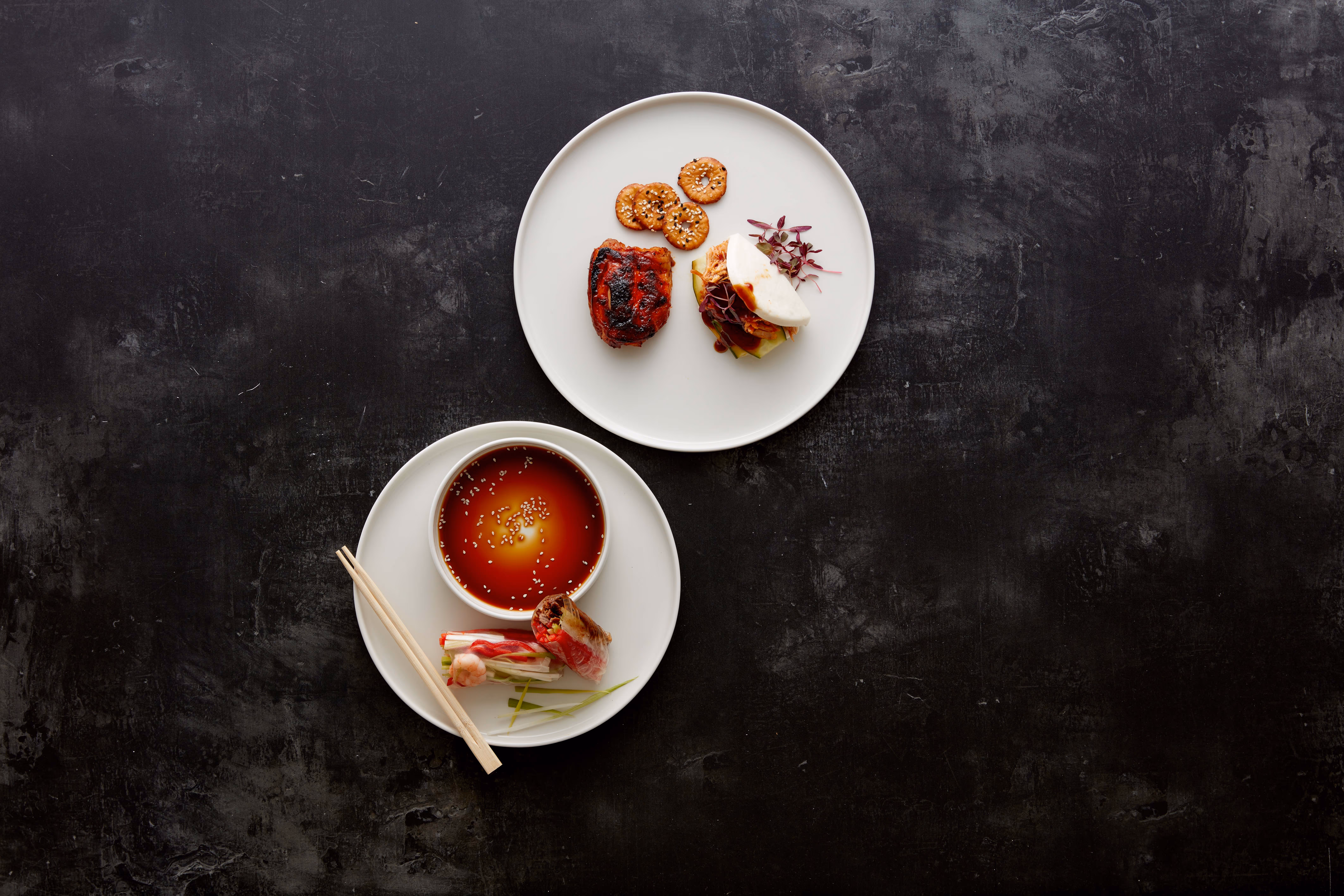 Modern angerichtete Vorspeisen und asiatische Spezialitäten auf hochwertigem Gastronomiegeschirr.