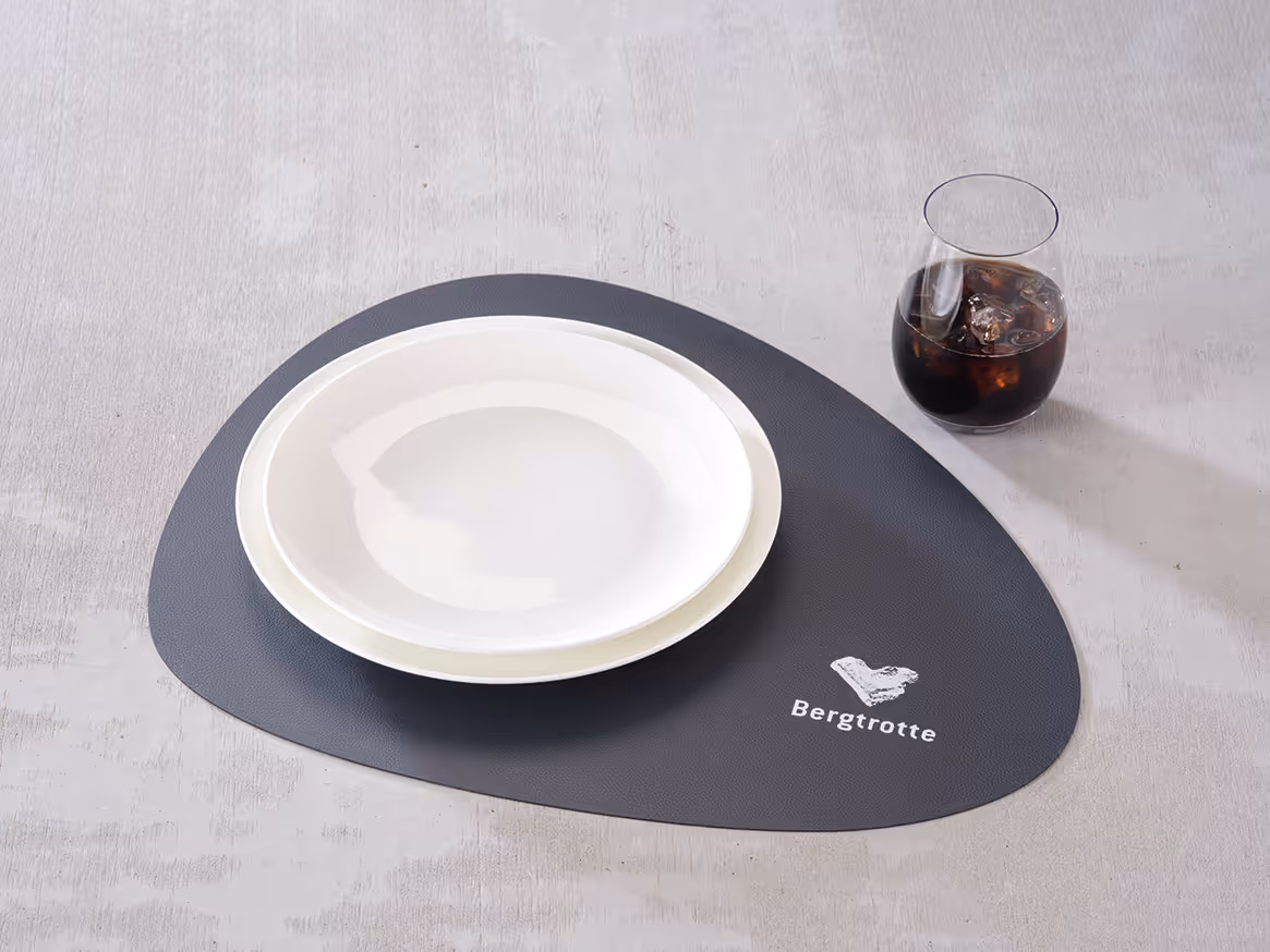 Personalisiertes Tischset mit Logo, kombiniert mit Teller und Getränk auf einem gedeckten Tisch.