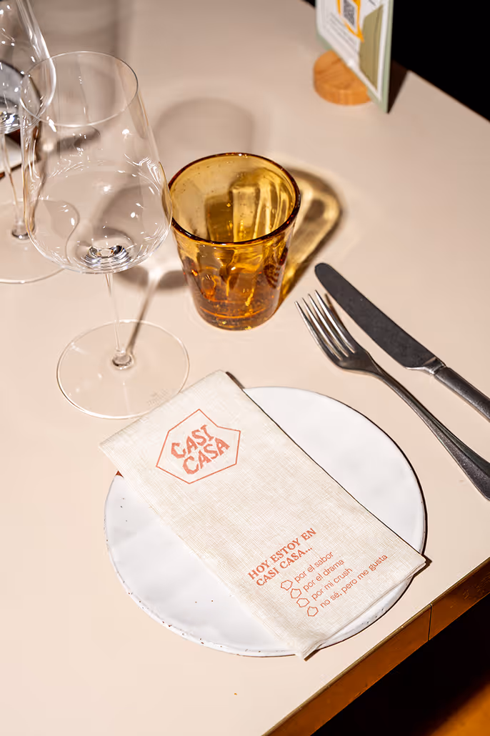 Hochwertige Serviette mit individuellem Druck auf einem elegant gedeckten Restauranttisch mit Gläsern und Besteck.