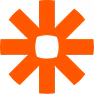 Orange asterisk symbol with eight thick rays on black background.