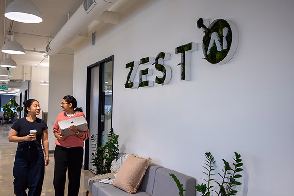 Zest AI employees gathering near a ZestAI green wall