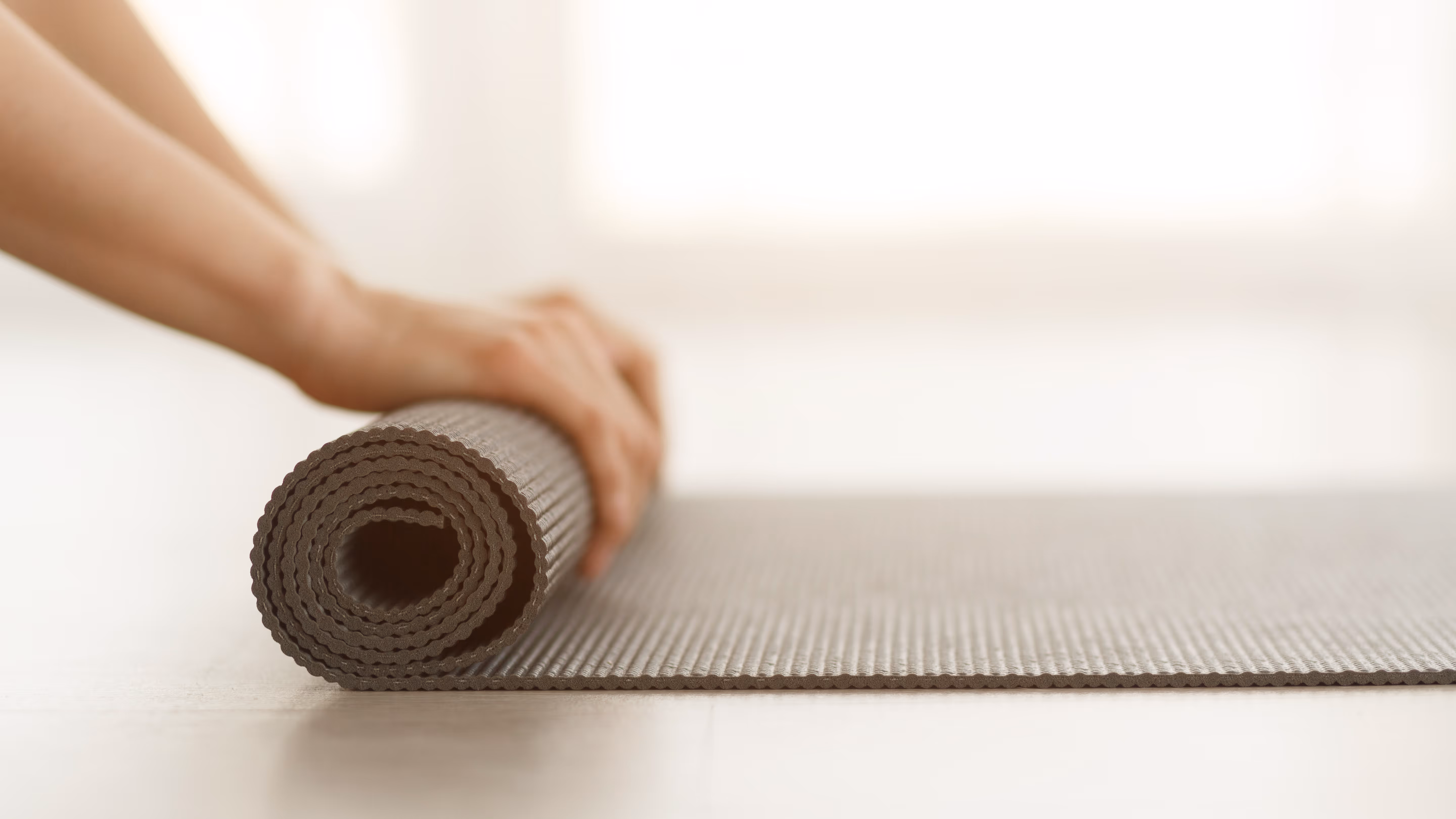 Person rolling up yoga mat stock image