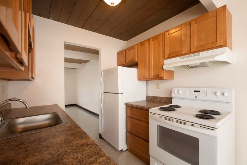 Kitchen with brown cabinets and white appliances