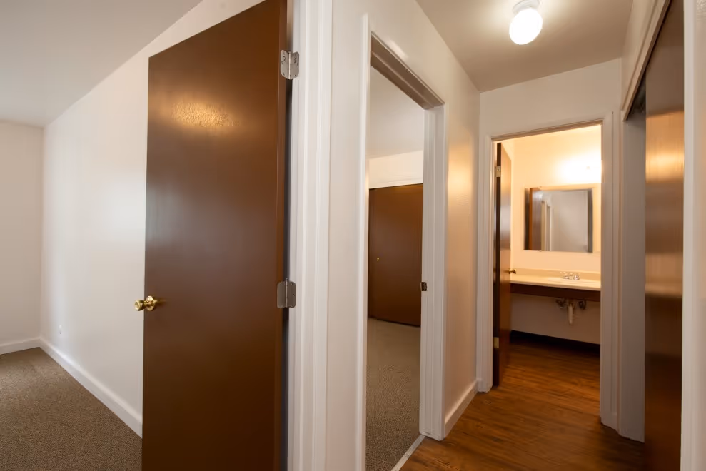 View from hallway into bedrooms and bathroom