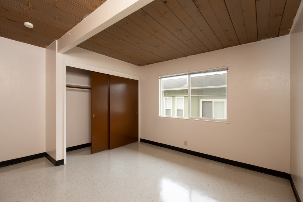 Unfurnished bedroom with large window and closet