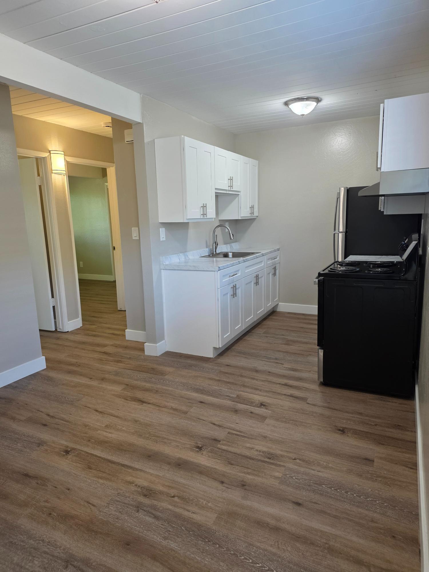 Kitchen with white cabinets and black appliances