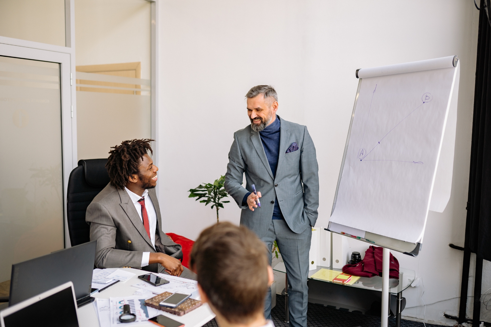 Two advisors collaborating at a whiteboard — the two-company advantage